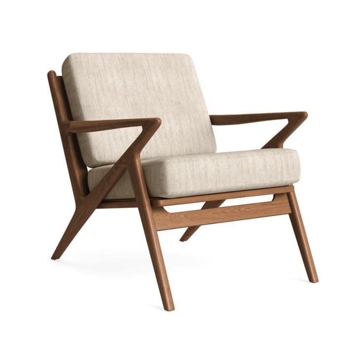 A sophisticated Mid-Century Modern lounge chair featuring an exposed dark wood frame with distinctive angled armrests and splayed tapered legs. The seat and backrest are fitted with thick, light beige upholstered cushions. — 3D model