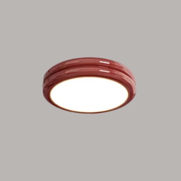 A round, red, flush-mount ceiling light with a glossy finish. It features a distinctive double-ring or tiered design on its exterior, and emits a bright, diffused white light from its center. — 3D model