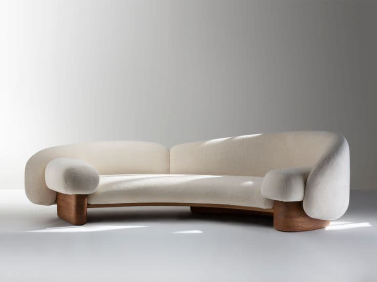 A modern, curved sofa featuring cream-colored bouclé upholstery and a distinctive, sculptural dark wood base. The design emphasizes organic forms with rounded edges and integrated arms. — 3D model