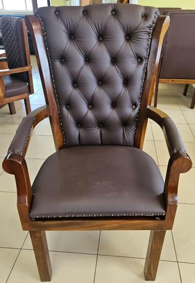 A traditional style armchair featuring a rich brown tufted backrest and seat, set within a dark wooden frame with exposed armrests. The upholstery is adorned with decorative nailhead trim. — 3D model
