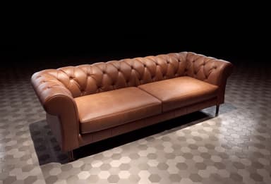 Brown leather Chesterfield style sofa with deep button tufting on the backrest and rolled arms, featuring two separate seat cushions and dark, tapered legs. — 3D model