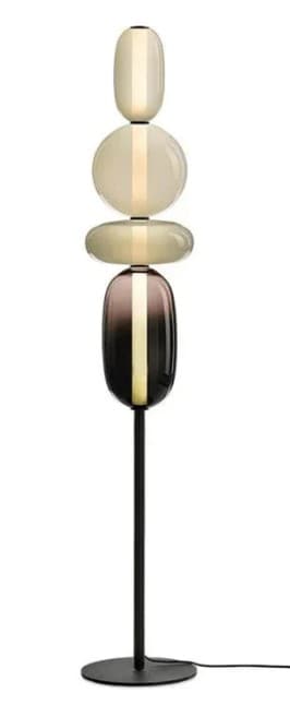 A modern floor lamp with a slender black metal stem and circular base. The lamp features a stacked arrangement of four diffuser elements made of frosted and colored glass, each illuminated from within by a central light source. The diffusers vary in shape and color, resembling polished stones or orbs, with the topmost elements being pale cream, the middle element a large translucent disc, the third element a flattened oval, and the bottom element a dark gradient transitioning from purple to black. — 3D model