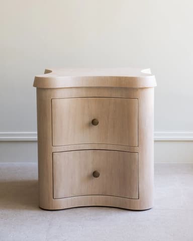 A light-colored wooden cabinet with a distinctive wavy-edged top and two curved drawers, featuring small brass knob pulls. — 3D model