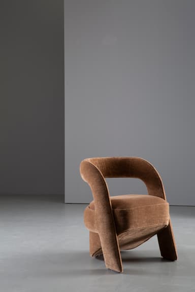 A contemporary sculptural accent chair fully upholstered in a textured medium brown fabric, featuring a continuous, curvilinear backrest and armrests that flow seamlessly into an integrated, upholstered cylindrical base. — 3D model