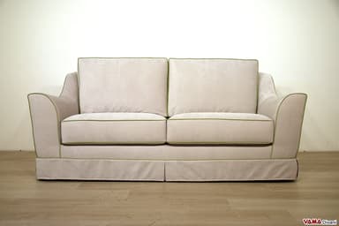 A two-seater sofa with plush cushions and a skirted base. The sofa features a light-colored fabric upholstery with contrasting green piping along the edges of the cushions, arms, and base. The armrests have a gently curved silhouette. — 3D model