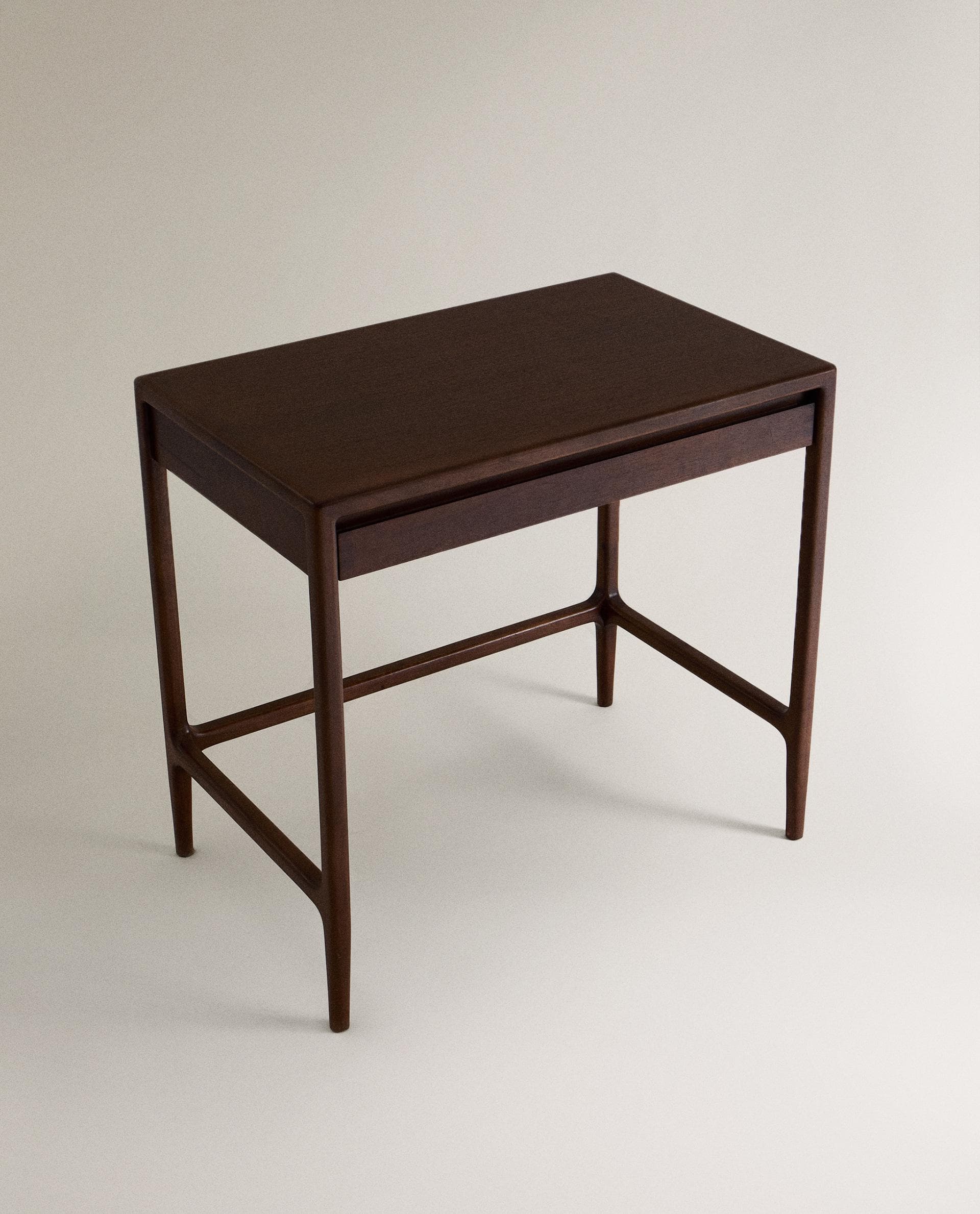 A minimalist dark wood writing desk featuring a rectangular top, a single shallow drawer, and four tapered legs connected by a stretcher base. — 3D model