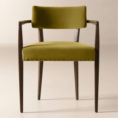 A wooden armchair with upholstered seat and back. The frame is constructed from dark wood with visible grain. The seat and back are upholstered in a textured, mustard-yellow velvet fabric. The upholstery on the seat is secured with a row of decorative brass tacks around its perimeter. The armrests are integrated into the wooden frame and extend from the backrest support to the front legs. — 3D model