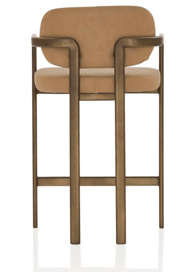 A contemporary bar stool featuring a sturdy metal frame with a bronzed finish, complemented by a padded seat and a gently curved backrest, both upholstered in a light brown fabric. The design includes integrated armrests and a footrest bar for comfort. — 3D model