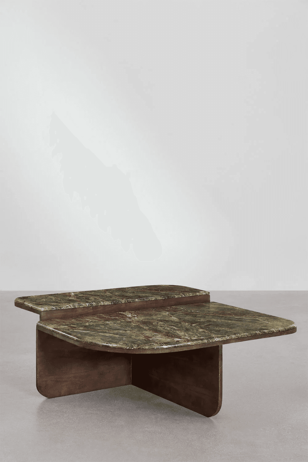 A two-tiered coffee table featuring rounded rectangular tops made of green marble with distinct reddish-brown and darker green veining. The base is constructed from dark, possibly stained wood or plywood, forming intersecting planes that support the two marble surfaces at staggered heights. The design exhibits a clean, sculptural aesthetic with smooth, curved edges throughout, presenting a substantial yet refined appearance. — 3D model