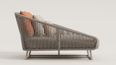 A contemporary daybed constructed with a woven rope frame and a metal base. It features a plush, light-colored cushion and several decorative pillows in coral and beige tones. The design suggests suitability for outdoor or modern indoor use. — 3D model