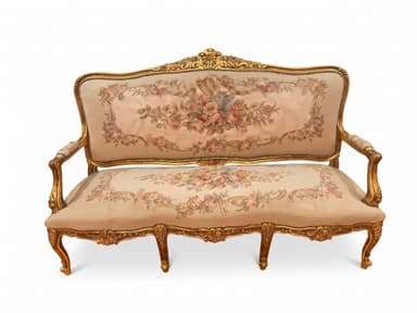 An ornate, antique-style settee in the Louis XV aesthetic, featuring an intricately carved giltwood frame and rich floral needlepoint upholstery. The frame showcases characteristic Rococo elements such as scrolling motifs, shell details, and acanthus leaves, all finished in a radiant gold. The backrest and seat are upholstered with a fine needlepoint fabric displaying a detailed floral pattern in various colors on a light, likely cream or beige, background. The armrests are partially upholstered, and the settee stands on elegant cabriole legs. — 3D model