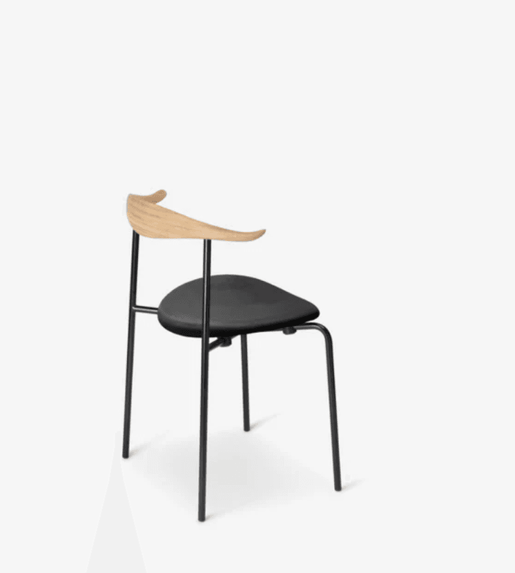 A modern dining chair with a molded wooden backrest and armrest integrated into a single piece. The seat is upholstered in black material. The frame and legs are constructed from slender black metal tubes, providing a minimalist and contemporary aesthetic. — 3D model