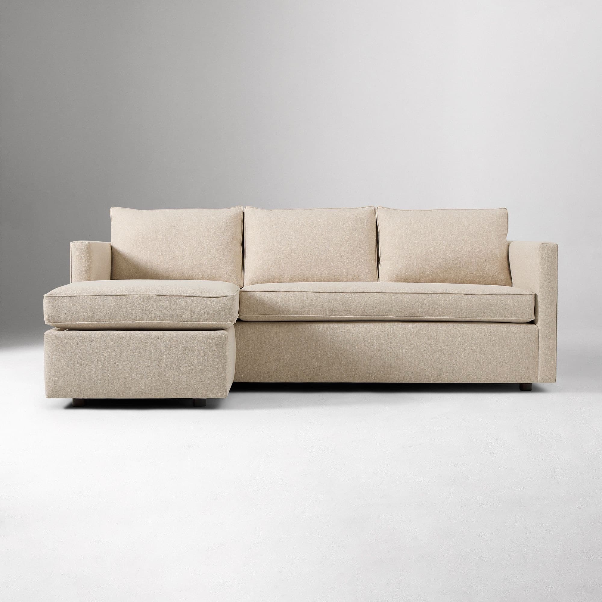 A contemporary sectional sofa upholstered in a light beige woven fabric, featuring a right-hand facing chaise lounge, low square arms, and loose back and seat cushions with tailored piping. — 3D model