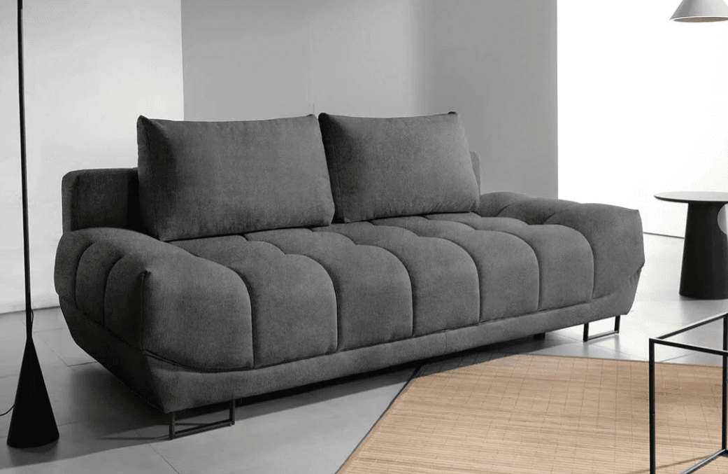 A contemporary gray fabric sofa featuring a distinctive tufted design on its seat and backrest, creating a segmented, plush appearance. The sofa is supported by minimalist black metal U-shaped legs, giving it a low-profile and modern aesthetic. Two loose back cushions provide additional comfort, contrasting with the fixed, sculpted seat base. — 3D model