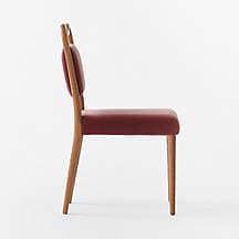 A contemporary dining chair with a curved wooden frame supporting upholstered seat and backrest. The chair has four tapered wooden legs. The upholstery appears to be a velvet fabric in a muted red or burgundy hue. — 3D model