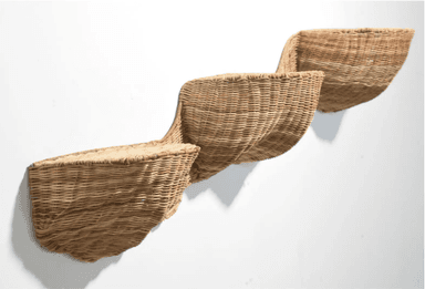 A trio of wall-mounted woven wicker seats arranged in a staggered, ascending pattern. Each seat is a distinct, curved basket-like form, constructed from natural-colored wicker. The design appears to be avant-garde, with the seats projecting outwards from a white wall. The closest seat on the left is the largest and lowest, with the subsequent seats progressively smaller and higher. — 3D model