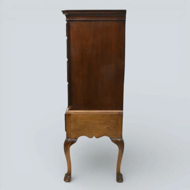 A traditional Queen Anne style highboy chest of drawers, constructed from medium-toned polished wood, featuring two stacked sections of multiple drawers with brass bail pulls, and supported by ornate cabriole legs ending in claw-and-ball feet. — 3D model
