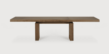 A rectangular dining table with a thick, solid wood top and two sturdy, block-style legs. The legs are constructed from vertical wooden planks joined together, creating a robust and contemporary aesthetic. The wood has a natural grain and a matte finish, suggesting a rustic or modern farmhouse style. — 3D model