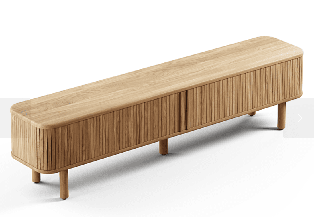 An elongated, low-profile media console crafted from light-toned oak wood, featuring rounded corners on its top surface and a slatted, horizontally sliding tambour door facade. The cabinet is supported by four tapered, cylindrical legs. — 3D model