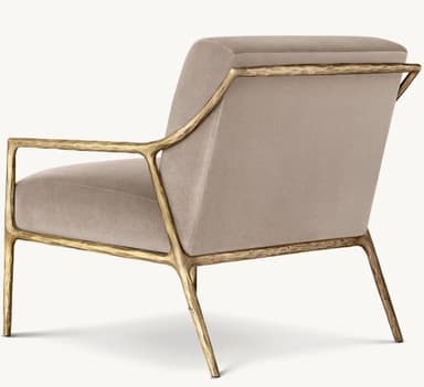 A modern armchair with a distinctive sculptural frame. The chair features a padded seat and backrest upholstered in a neutral fabric, supported by an open, organic-shaped frame that extends to form the legs and armrests. The frame has a textured, metallic finish. — 3D model