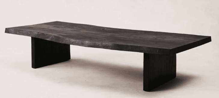 A low-profile, rectangular coffee table featuring a live-edge solid wood top and two robust slab legs, all finished in a uniform black. — 3D model