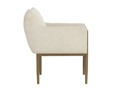 A contemporary armchair featuring a structured yet inviting design. It has a light-toned, textured boucle-like upholstery covering the seat, back, and armrests. The chair is supported by a slender metal frame with a warm, aged brass or bronze finish, which extends upwards to elegantly wrap around the outside of the upholstered armrests. The legs are straight and tapered, providing a clean, modern aesthetic. — 3D model