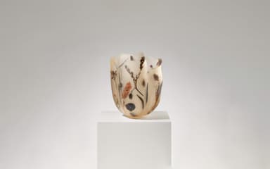 An irregular, organic-shaped vase crafted from translucent resin with various dried botanicals, including leaves, flowers, and stems, embedded within its walls. The resin exhibits a yellowish-amber hue and a matte, frosted finish. The top rim is uneven and undulating, contributing to its sculptural quality. — 3D model