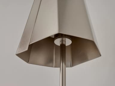 A close-up image of a modern pendant light's hexagonal, faceted shade, crafted from brushed metal. A central rod passes through the bottom opening, connecting to the light source or suspension mechanism. The shade features distinct angular folds, giving it a geometric appearance. — 3D model