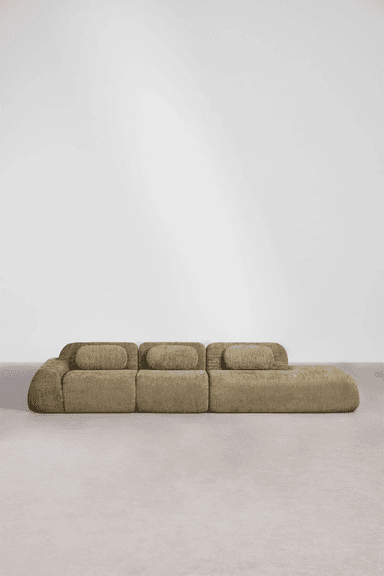 A long, low-profile modular sectional sofa composed of multiple units, upholstered in a textured khaki-colored fabric. The design features soft, rounded edges and cylindrical back cushions that rest atop the base units. The sofa appears to be in excellent, new condition, placed on a light-colored floor against a plain white wall. — 3D model