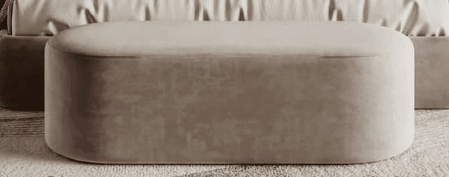 A low-profile, elongated oval ottoman with full upholstery in a neutral beige or taupe color. Its seamless, rounded form and lack of visible legs suggest a modern, minimalist design. — 3D model