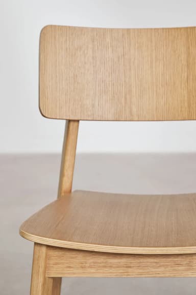 A modern, minimalist side chair constructed from light-colored solid wood, featuring a flat seat and a curved backrest attached to the rear legs. — 3D model