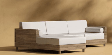 A sectional sofa with a chaise lounge extension. The sofa features a low-profile wooden frame with visible wood grain and light-colored upholstered cushions. It has a modern, minimalist design with clean lines and square arms. One end of the sofa extends into a chaise, and the sofa includes a cylindrical bolster pillow. — 3D model