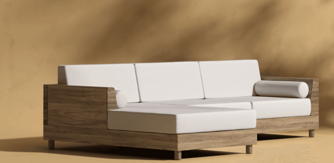 A sectional sofa with a chaise lounge extension. The sofa features a low-profile wooden frame with visible wood grain and light-colored upholstered cushions. It has a modern, minimalist design with clean lines and square arms. One end of the sofa extends into a chaise, and the sofa includes a cylindrical bolster pillow. — 3D model