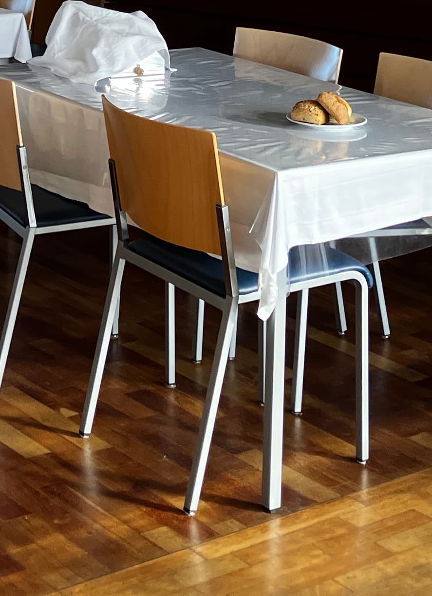 A contemporary armless chair featuring a silver-colored metal frame, a navy blue upholstered seat cushion, and a curved light-toned wooden backrest. — 3D model
