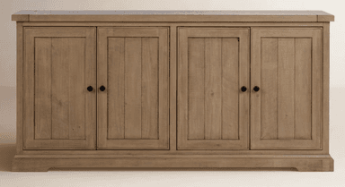 A wooden sideboard featuring four cabinet doors arranged in two symmetrical pairs. Each door has a vertical plank design within a recessed panel and is fitted with a small, round, black knob. The top surface appears to be a distinct piece with a slight overhang. The base of the unit has a subtle, molded plinth. — 3D model
