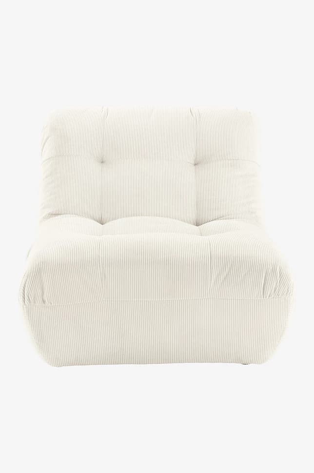 A low-profile armchair upholstered in cream-colored corduroy fabric. The armchair features a tufted backrest and seat, with plush, rounded armrests that seamlessly integrate into the base. The corduroy material exhibits distinct vertical ribbing, contributing to its textured appearance. The overall design is modular and contemporary, emphasizing comfort and a relaxed aesthetic. — 3D model