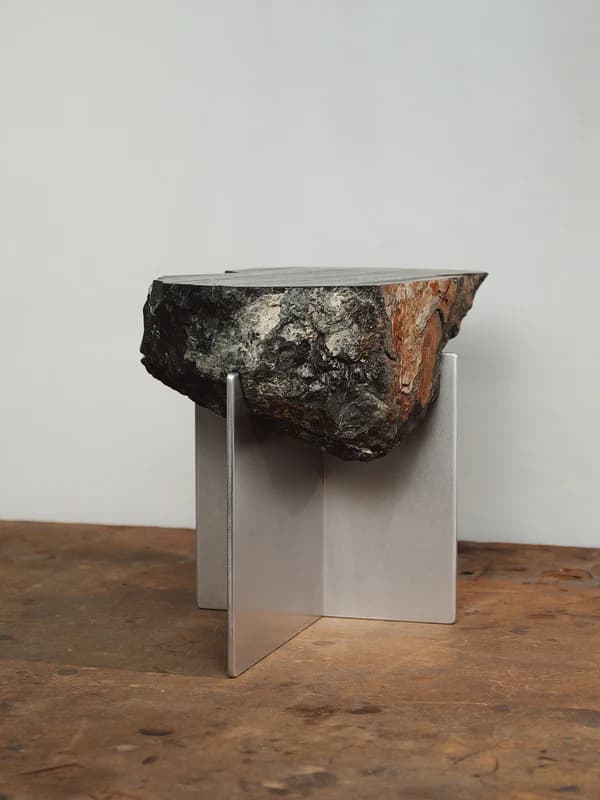 A side table featuring a natural, unrefined log slice as the tabletop, supported by a minimalist, modern base. The tabletop exhibits raw bark texture and irregular edges, while the base is constructed from polished metal, forming a clean, geometric structure. — 3D model