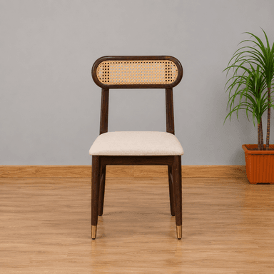 A contemporary dining chair featuring a dark stained wooden frame, a distinctive oval-shaped backrest with natural cane webbing, and a light beige upholstered seat. The chair's tapered legs are accented with brass ferrules on the front two feet. — 3D model