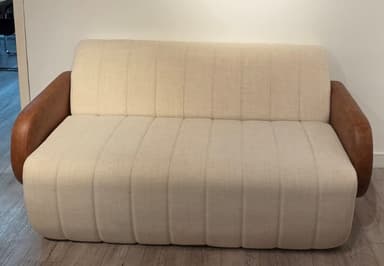 A modern two-seater sofa, commonly known as a loveseat, featuring distinctive channel tufting on the seat and back, complemented by contrasting brown leather armrests. — 3D model