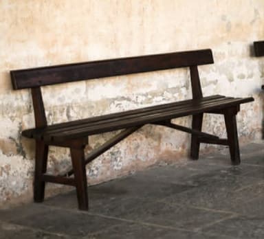 A dark brown wooden bench with a slatted seat and backrest, featuring a simple, robust design. It has four sturdy legs and is rendered against a white background. — 3D model