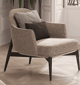 A modern upholstered lounge chair with a beige and brown textured fabric, featuring a supportive back and wide armrests. The chair is designed for comfort, with two loose cushions—one large back cushion in a lighter gray-beige and a smaller, darker brown lumbar cushion. The seat is deep, and the chair rests on a dark-stained wooden frame with slender, tapered legs. — 3D model