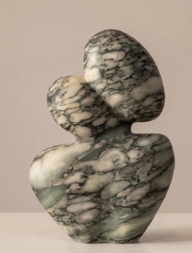 An abstract, biomorphic sculpture made from veined marble. The piece features a curvilinear, organic form with a wider base tapering up to two rounded, interlocking shapes at the top. The marble exhibits natural patterns of green, grey, and white veining, and the entire surface is highly polished. — 3D model