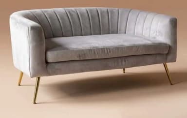A light grey upholstered loveseat featuring a channel-tufted backrest and rounded arms. The piece is supported by four slender, angled gold-finished metal legs, giving it a modern and elegant appearance. The seating area consists of a single, continuous cushion. — 3D model