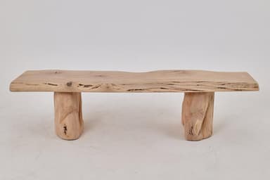 A rustic coffee table constructed from natural wood elements. The tabletop is a single slab with a live edge, showcasing the natural contours and grain of the wood. It is supported by two solid, irregularly shaped wooden block legs that mimic the organic form of tree trunks. The overall design emphasizes natural forms and textures. — 3D model