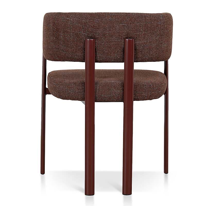 An armless contemporary chair featuring a textured brown fabric upholstery on both its seat and backrest. The chair is supported by a slender, dark brown tubular metal frame that forms the legs and provides structural support. A distinctive design element includes two prominent, vertical, cylindrical metal bars positioned centrally on the back, appearing to extend from the seat level upwards to frame the backrest. — 3D model