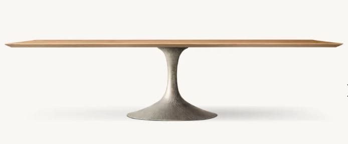 A rectangular dining table featuring a light-toned wooden top with a subtle chamfered edge, supported by a single, central pedestal base. The base has a distinctive tapered, bell-shaped design and appears to be made from a textured, grey-colored metal, possibly cast aluminum or iron, giving it an industrial yet refined appearance. — 3D model