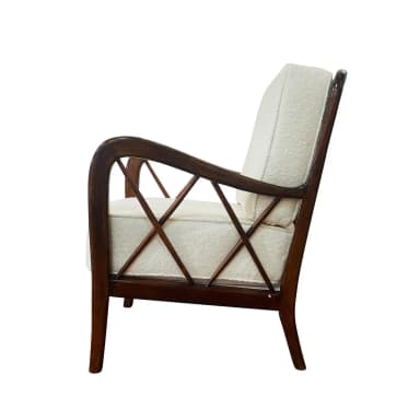 A wooden armchair with a dark stained finish and upholstered seat and back cushions. The armrests have a curved silhouette, and the back features a geometric lattice pattern created by intersecting wooden slats. The legs are slender and tapered. — 3D model