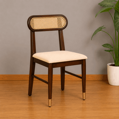 A contemporary dining chair featuring a dark stained wooden frame, a distinctive oval-shaped backrest with natural cane webbing, and a light beige upholstered seat. The chair's tapered legs are accented with brass ferrules on the front two feet. — 3D model