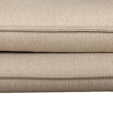 A contemporary sectional sofa, seen from the rear and side, upholstered in light beige/greige fabric with black metal legs. It features multiple loose back cushions and a low-profile design. — 3D model