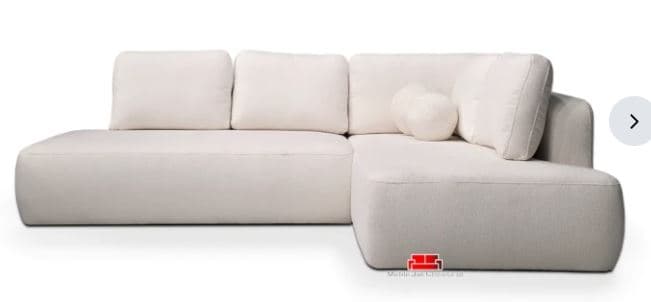 A modern, off-white L-shaped sectional sofa with soft, rounded edges and a low profile. It features plush seat and back cushions, and two spherical accent pillows. The fabric appears textured, possibly bouclé. — 3D model